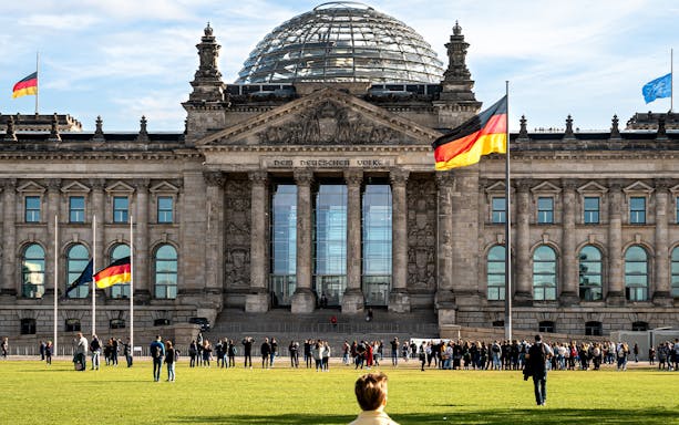 Reichstag building with visitors in Berlin's Parliament District.