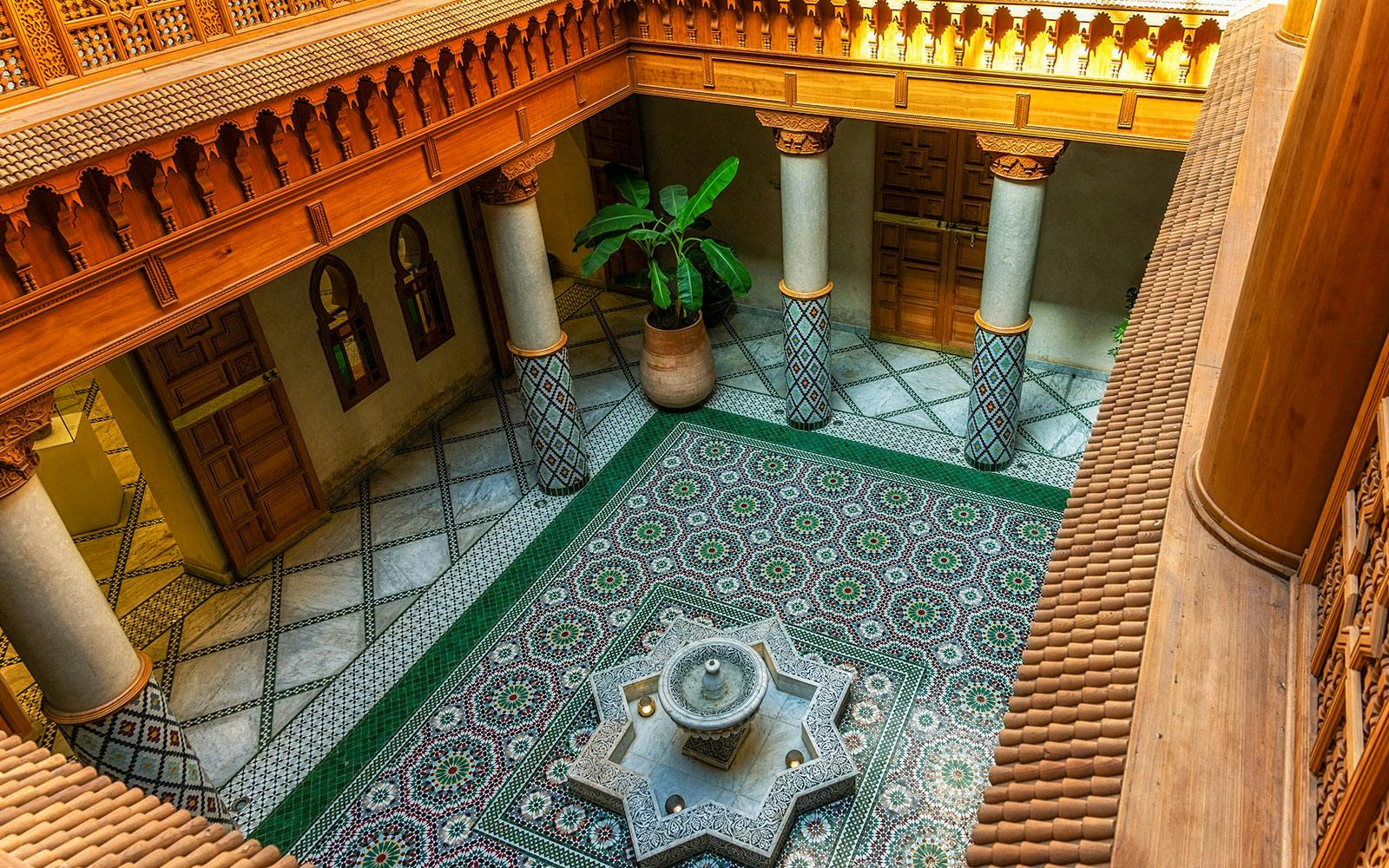 Moroccan Culinary Arts Museum interior with ornate tiles and central fountain.