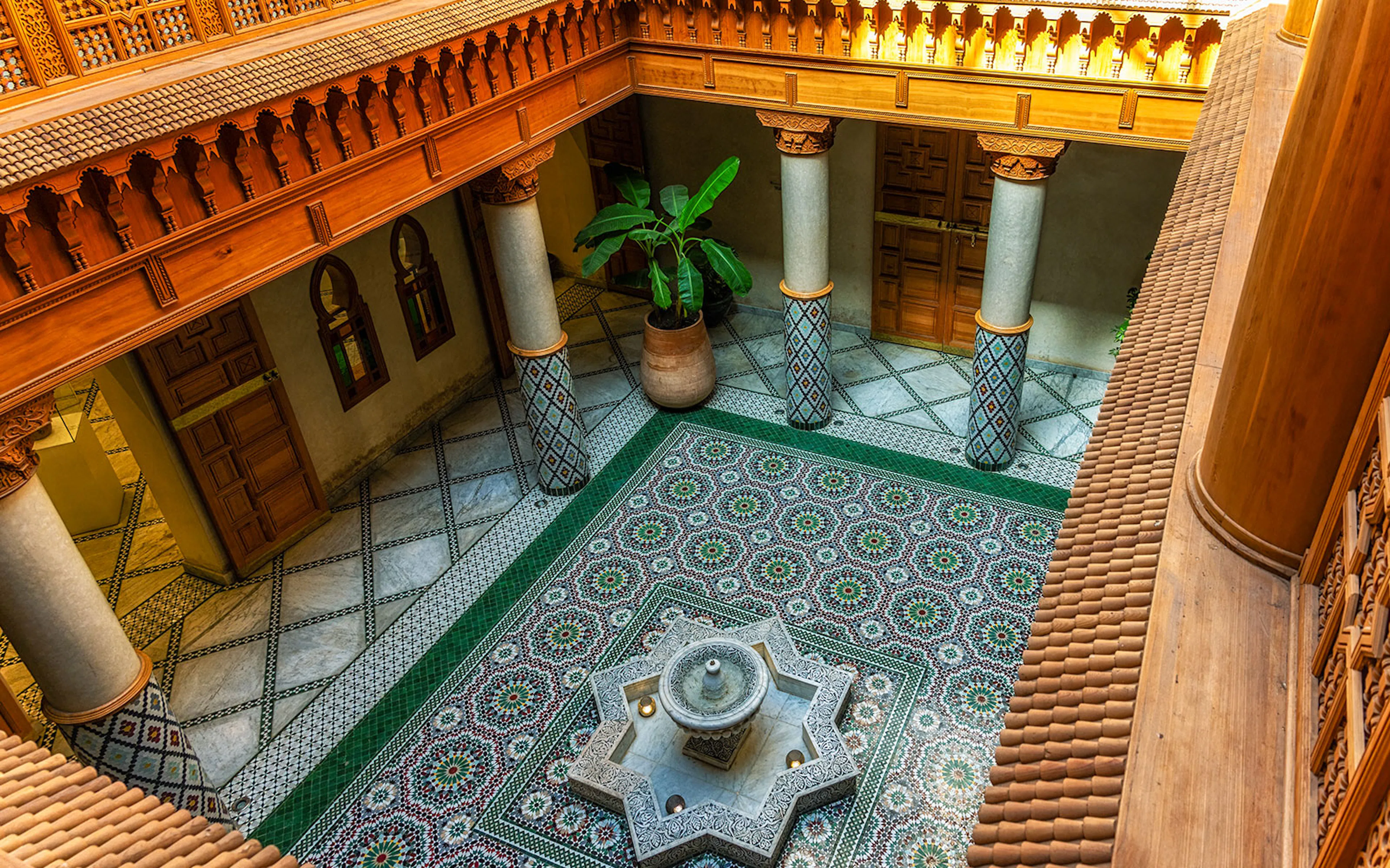 Moroccan Culinary Arts Museum interior with ornate tiles and central fountain.