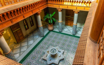 Moroccan Culinary Arts Museum interior with ornate tiles and central fountain.