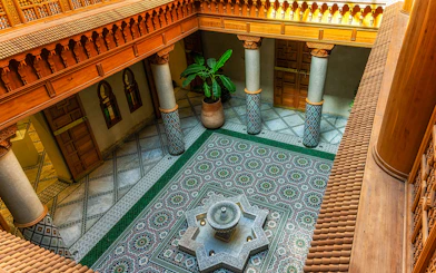 Moroccan Culinary Arts Museum interior with ornate tiles and central fountain.
