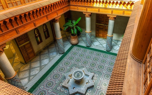 Moroccan Culinary Arts Museum interior with ornate tiles and central fountain.