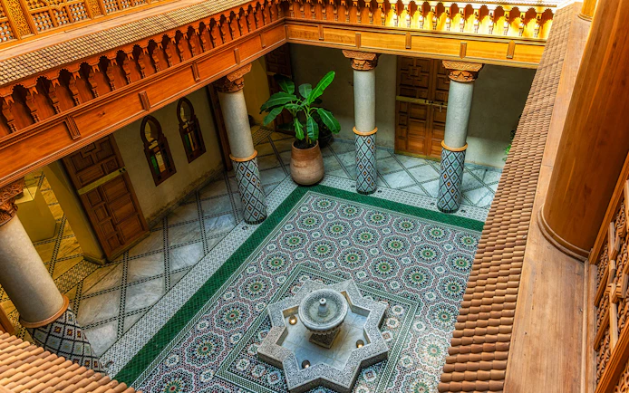 Moroccan Culinary Arts Museum interior with ornate tiles and central fountain.