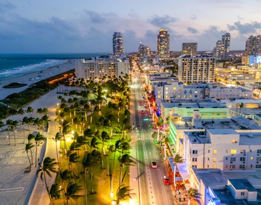 Ocean Drive in Miami South Beach with neon lights and palm trees at night.