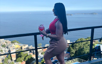 Woman enjoying a drink with a view of Vidigal and the ocean in Rio de Janeiro.