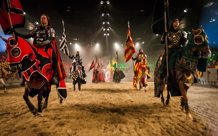 Knights on horseback in a jousting arena at Medieval Times Dinner and Show.