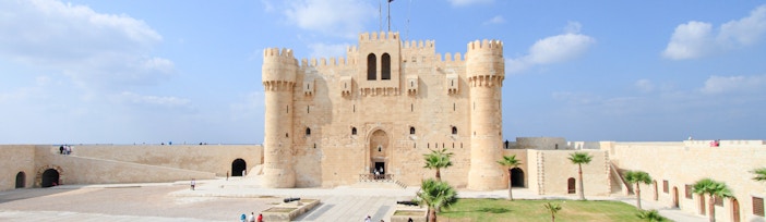 Panoramic view of Qaitbay Citadel in Alexandria with surrounding courtyard and cannons.