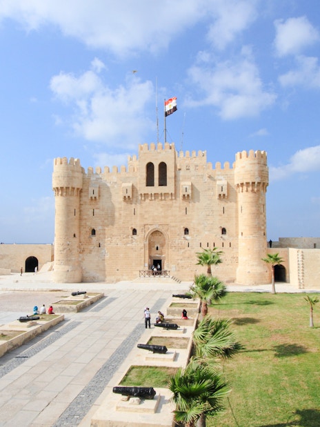 Panoramic view of Qaitbay Citadel in Alexandria with surrounding courtyard and cannons.