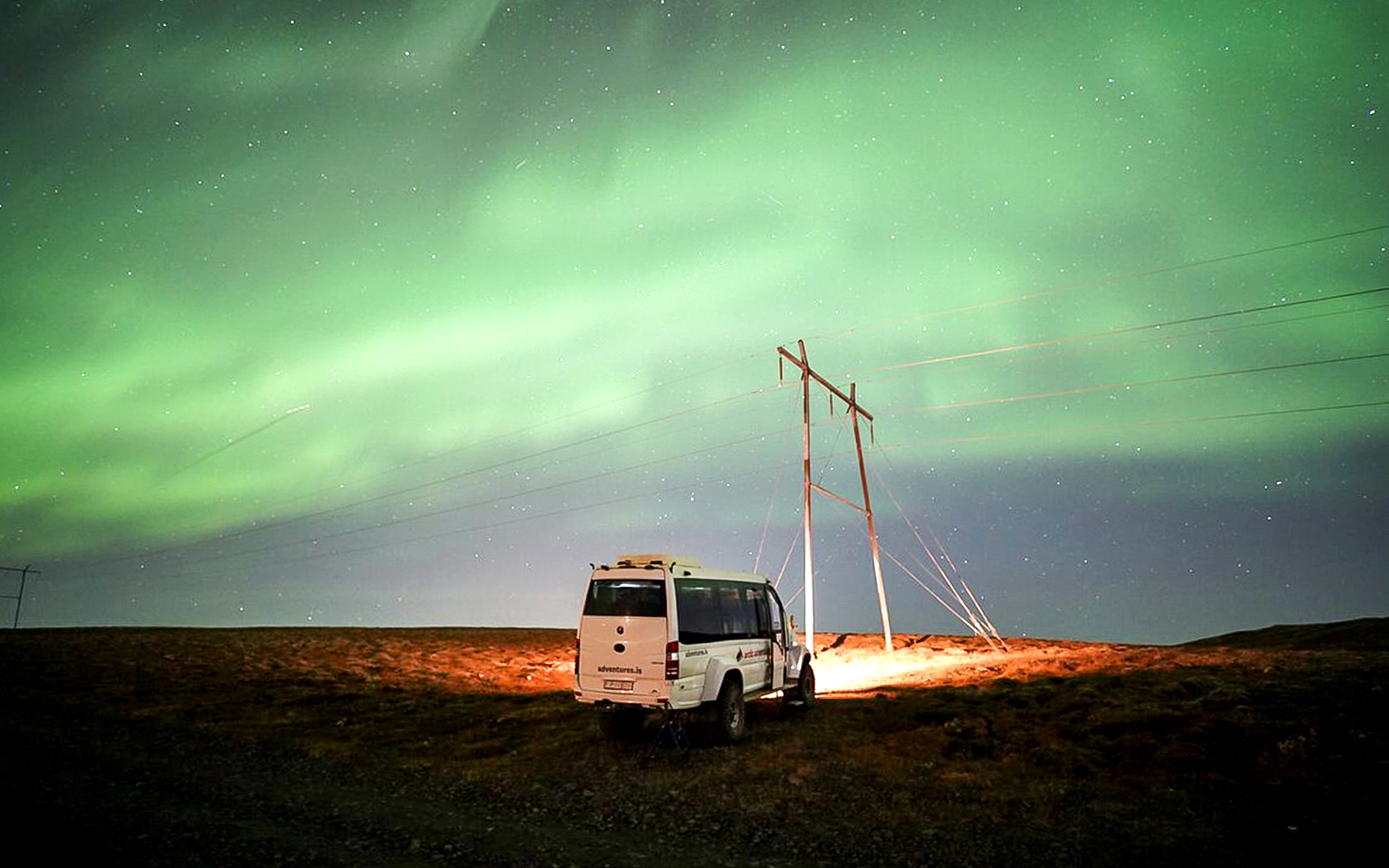Northern lights over a jeep on a Premium Northern Lights Super Jeep Tour.