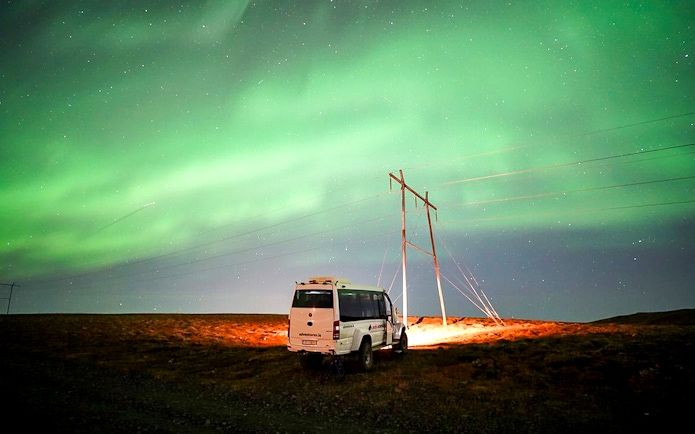 Northern lights over a jeep on a Premium Northern Lights Super Jeep Tour.
