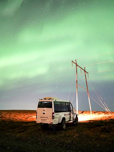 Northern lights over a jeep on a Premium Northern Lights Super Jeep Tour.