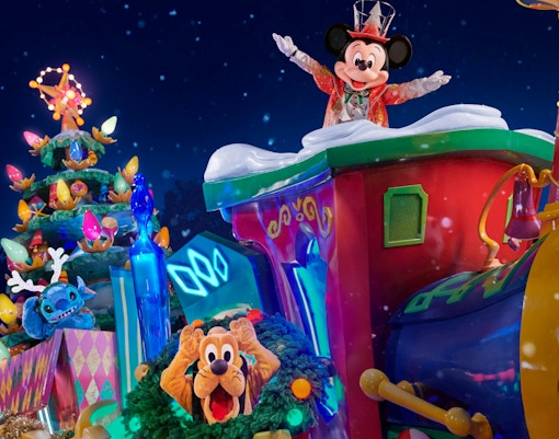 Mickey Mouse leading Christmas parade at Disneyland Paris with festive decorations