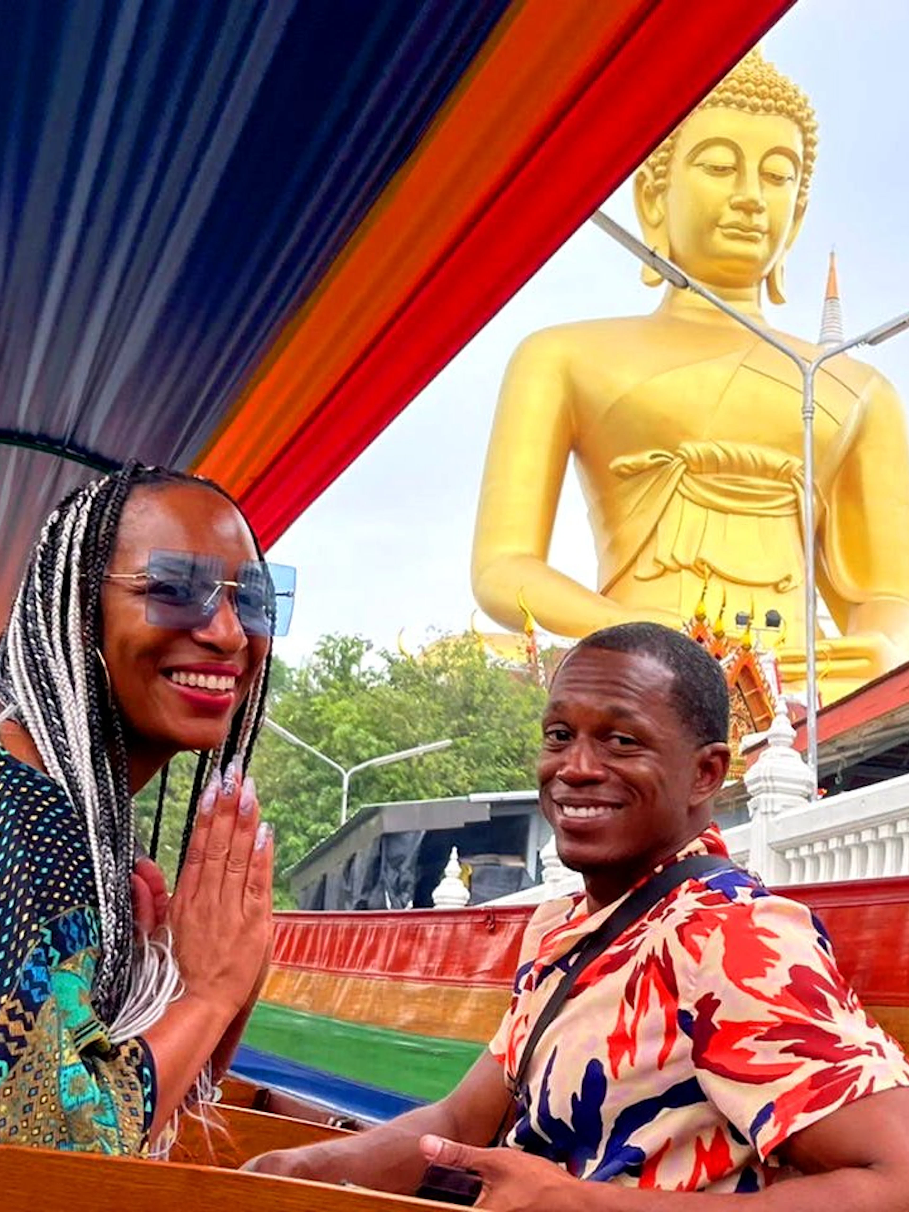 Longtail boat ride past a golden Buddha statue on Bangkok Canal Tour.