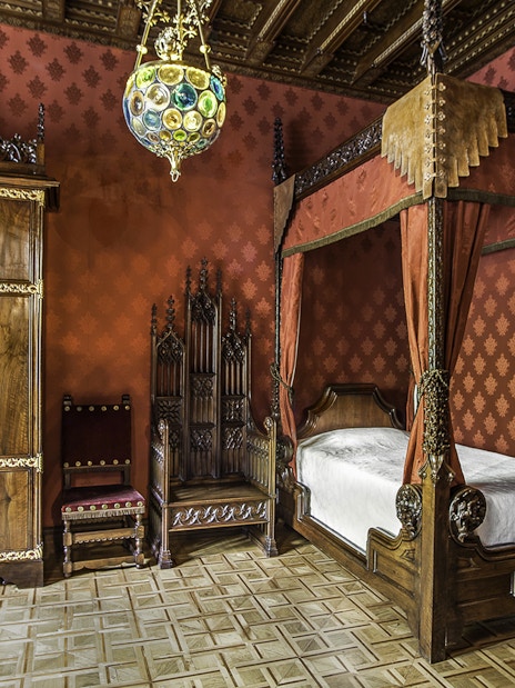 Casa Amatller bedroom with ornate wooden furniture and red decor, Barcelona.