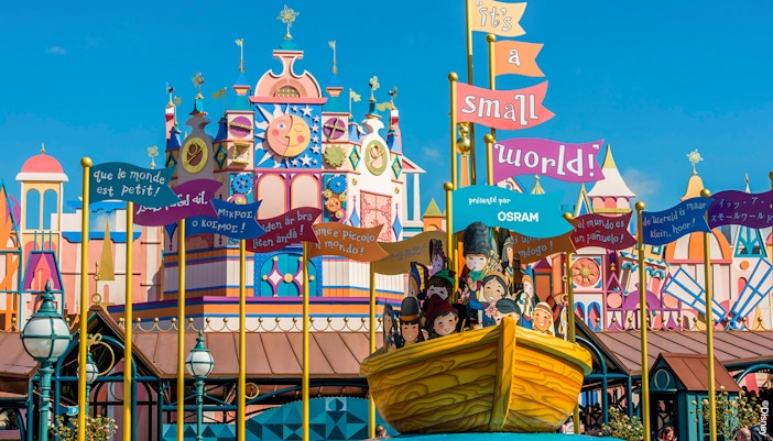 Colorful facade of "it's a small world" ride at Disneyland Paris Park with international signs.