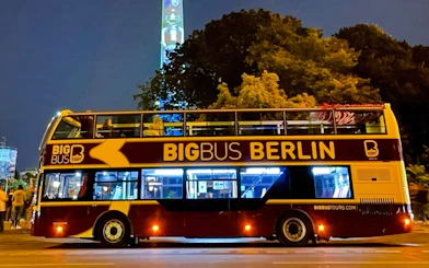 Open-top tour bus at Berlin Lights Festival with illuminated TV Tower in background.