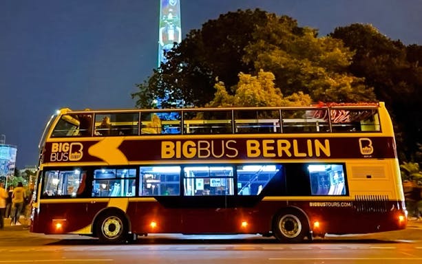 Open-top tour bus at Berlin Lights Festival with illuminated TV Tower in background.