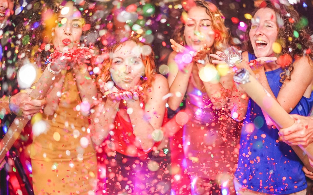People celebrating with confetti at a New Year's Eve party.
