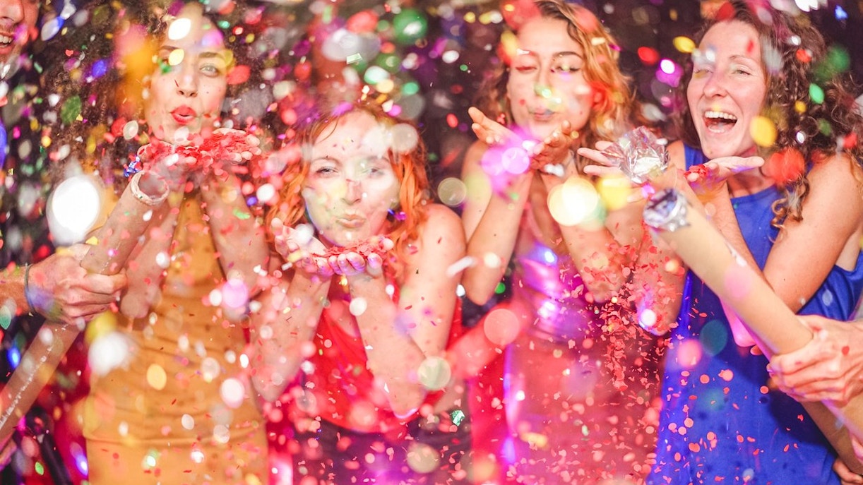 People celebrating with confetti at a New Year's Eve party.