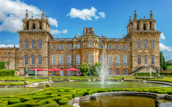 Blenheim Palace gardens with fountains and historic architecture, London tour.