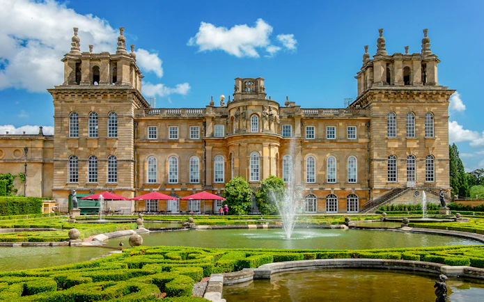 Blenheim Palace gardens with fountains and historic architecture, London tour.