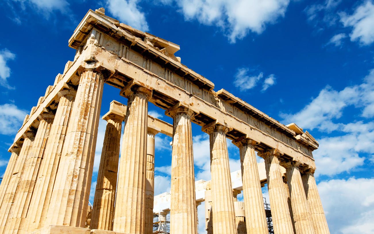 Parthenon temple on the Acropolis in Athens under a blue sky.