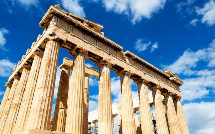 Parthenon temple on the Acropolis in Athens under a blue sky.