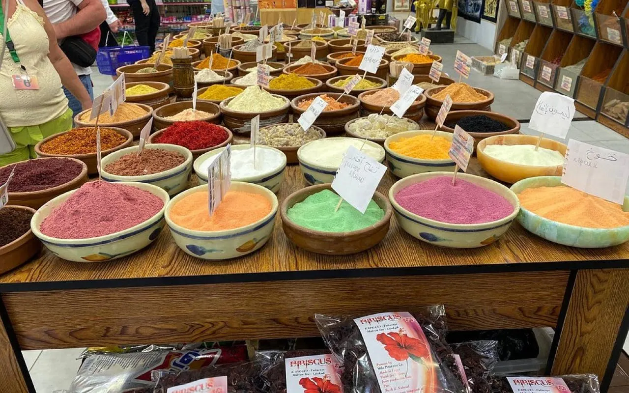 Bowls of colorful spices on display in a Hurghada market during a private shopping tour.