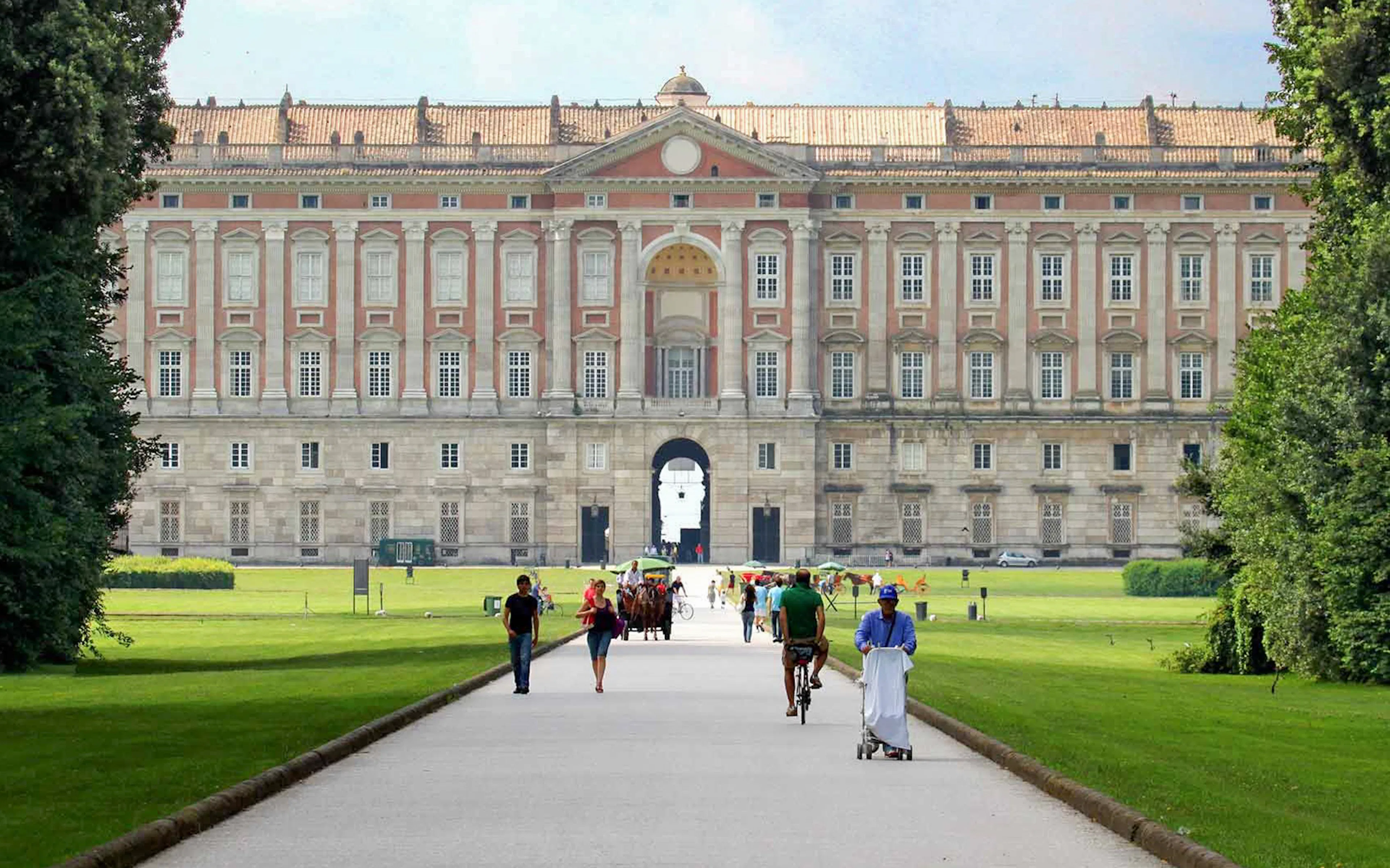 Visitors strolling through the gardens of the Royal Palace of Caserta.