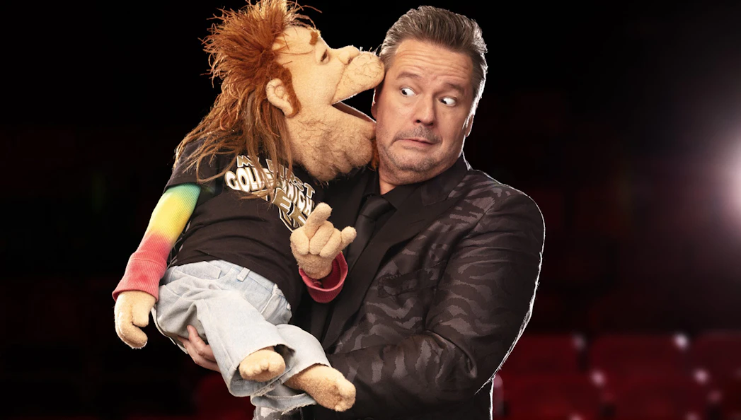 Ventriloquist with puppet on stage, part of "Terry Fator: One Man, a Hundred Voices, a Thousand Laughs!" show.
