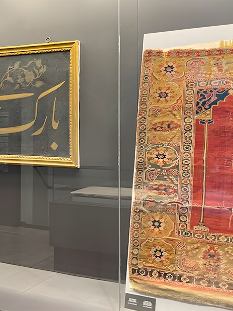 Framed calligraphy and ornate rug display at Hagia Sophia Museum.