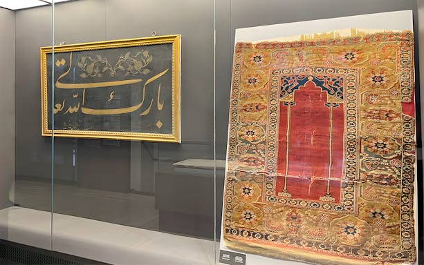 Framed calligraphy and ornate rug display at Hagia Sophia Museum.