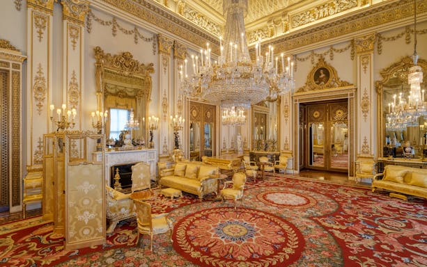 Buckingham Palace State Room with ornate chandeliers and gilded decor.