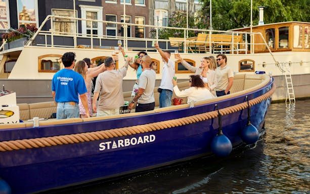 Guests enjoying drinks on a canal cruise in Amsterdam.