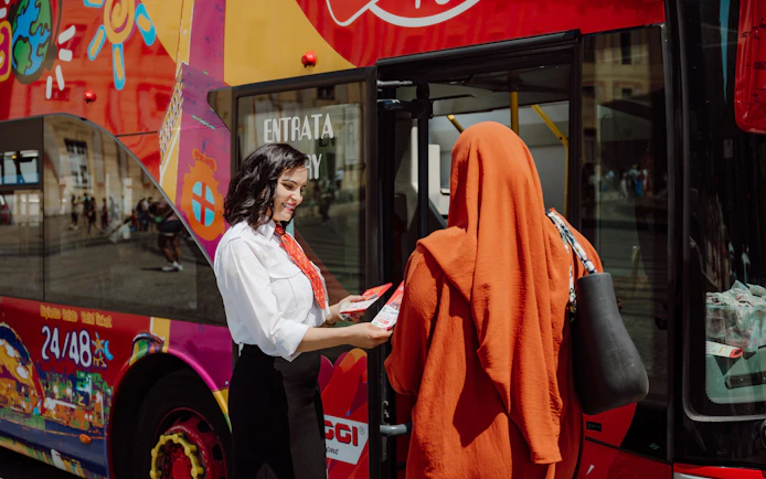 Tourist with guide boarding Genoa city sightseeing bus.
