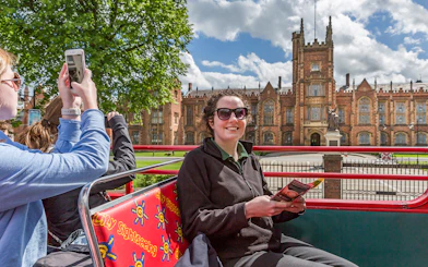 HOHO tour bus at Queen's University, Belfast with passengers enjoying the view.