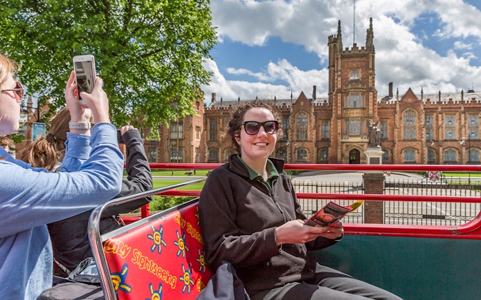 HOHO tour bus at Queen's University, Belfast with passengers enjoying the view.