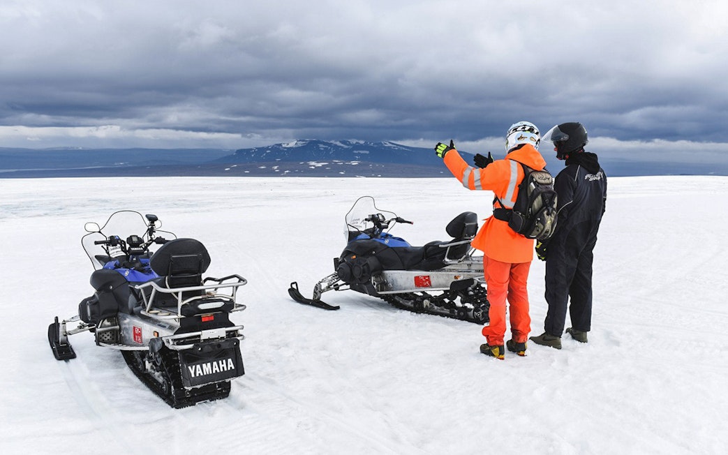 Snowmobilers on glacier during Secret Lagoon hot spring tour in Iceland.