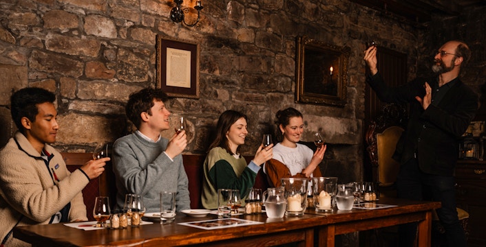 Guests enjoying whisky tasting at an underground tour in Edinburgh.
