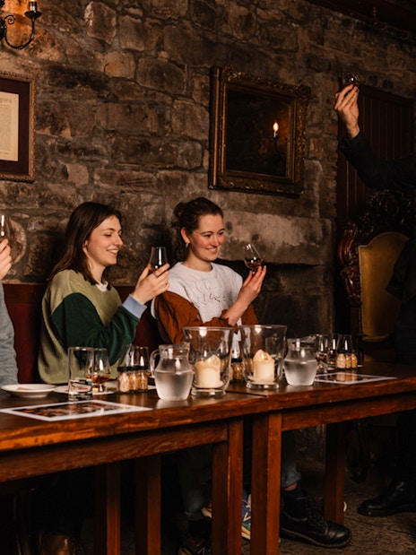 Guests enjoying whisky tasting at an underground tour in Edinburgh.