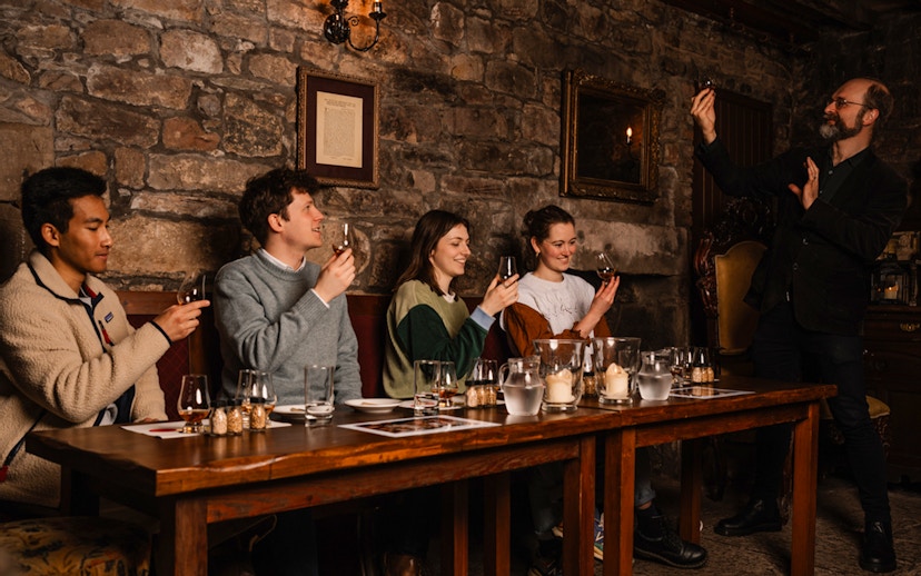 Guests enjoying whisky tasting at an underground tour in Edinburgh.