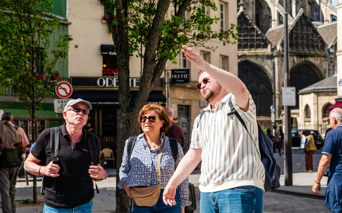 Tour guide explaining Notre-Dame's exterior to visitors on Île de la Cité, Paris.