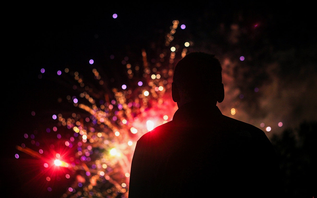 Silhouette watching Dubai New Year 2024 fireworks display.