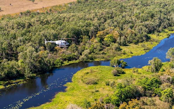 Helicopter flying over Finniss River landscape on Top End Safari Camp tour from Darwin.