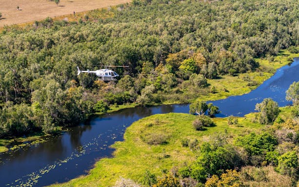Helicopter flying over Finniss River landscape on Top End Safari Camp tour from Darwin.