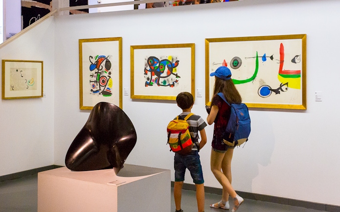 Tourists viewing abstract art in Poble Espanyol museum, Barcelona.