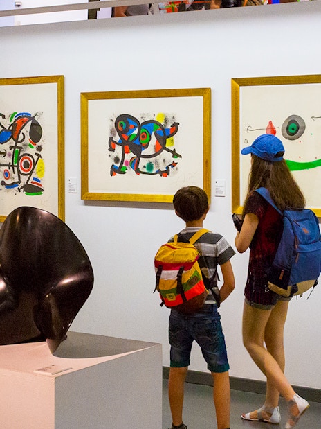 Tourists viewing abstract art in Poble Espanyol museum, Barcelona.