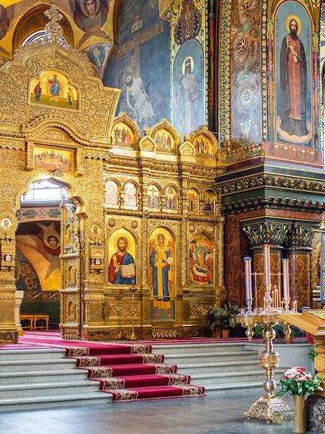 Interior of St Vitus Cathedral featuring ornate gold altar and religious iconography.