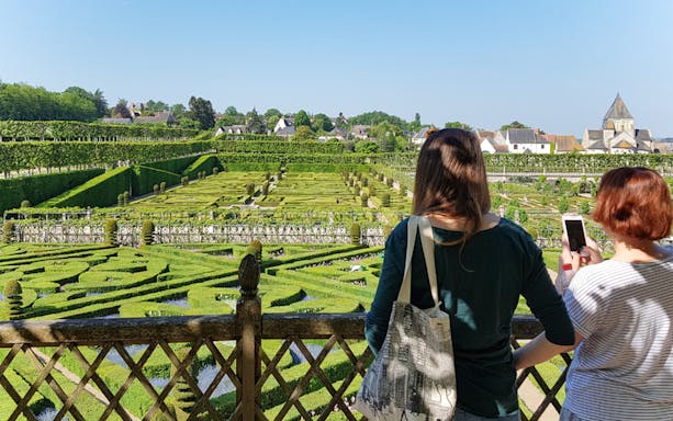 Visitors overlooking the intricate hedges of Chateau de Villandry gardens in France.