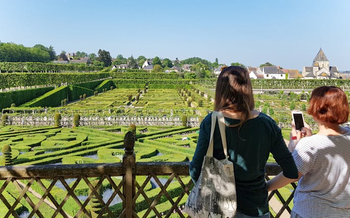 Visitors overlooking the intricate hedges of Chateau de Villandry gardens in France.